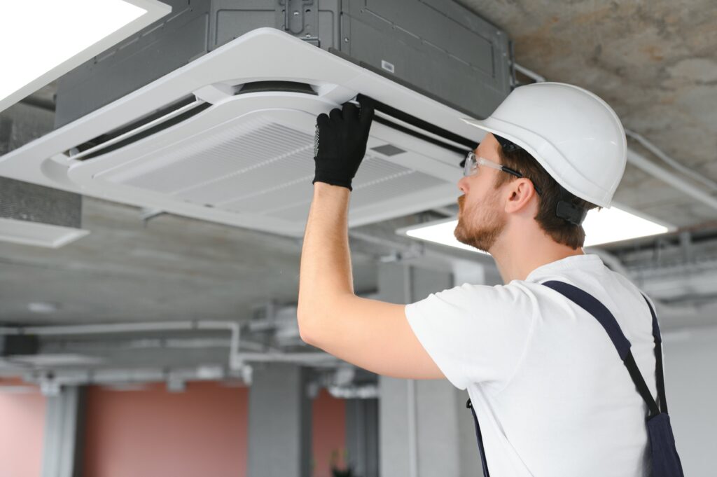 happy-male-technician-repairing-air-conditioner-min